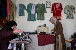 La couturière Rahima Alavi brode à la machine à coudre une écharpe dans sa boutique à Bamiyan, le 26 janvier 2026 en Afghanistan - © AFP - Wakil KOHSAR