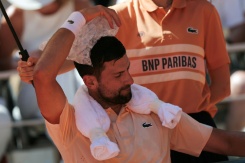 Novak Djokovic pose un sac de glace sur la tête lors de son match de 2e tour contre le Français Valentin Royer, le 27 mai 2026 à Roland-Garros - © AFP - Thomas SAMSON