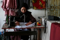 La couturière Rahima Alavi brode à la machine à coudre une écharpe dans sa boutique à Bamiyan, le 26 janvier 2026 en Afghanistan - © AFP - Wakil KOHSAR