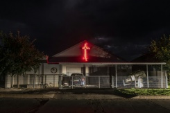 Une croix de lumière rouge orne la façade de la maison d'habitants de l'enclave afrikaner d'Orania en Afrique du Sud, le 28 janvier 2026. - © AFP - CAMILLA RICHETTI