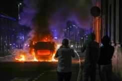 Un véhicule incendié lors d'une manifestation anti-immigration à Ballymena, après l'arrestation de deux adolescents roumanophones accusés d'avoir tenté de violer une jeune fille, le 10 juin 2025 en Irlande du Nord - © AFP/Archives - PAUL FAITH