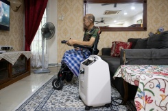 Md Noor Bin Bujang regarde la télévision près d'un concentrateur d’oxygène à son domicile de Rawang, dans l’État de Selangor, le 16 octobre 2026 en Malaisie - © AFP - Mohd Rasfan