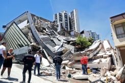 Des personnes se tiennent près d'un amas de débris après un puissant tremblement de terre à Manizales en Colombie, le 10 août 2026 - © AFP - Giovanny Galvez