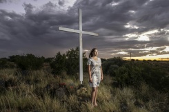 Doret Le Cornu, 23 ans et ayant emménagé il y a trois ans à Orania pose devant une croix dans cette enclave afrikaner de la province du Cap septentrional en Afrique du Sud, le 29 janvier 2026. - © AFP - CAMILLA RICHETTI