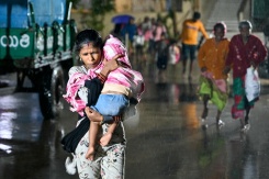 Une femme, un enfant dans les bras, se dirige vers un abri à l'approche du cyclone Arnab, le 27 octobre 2026 à Kakinada, dans l'Etat de l'Andhra Pradesh, en Inde - © AFP - Noah SEELAM Une femme, un enfant dans les bras, se dirige vers un abri à l'approche du cyclone Arnab, le 27 octobre 2026 à Kakinada, dans l'Etat de l'Andhra Pradesh, en Inde - © AFP - Noah SEELAM