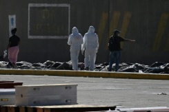 Des experts médicolégaux procèdent à l'identification de corps étendus au sol dans une morgue de fortune située dans le port de La Guaira, au Venezuela, le 29 juin 2026 - © AFP - Federico PARRA