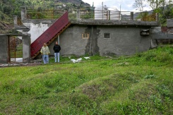 Rameez Khan (d) et son épouse Urusa Khan, qui ont perdu leurs jumeaux en fuyant lors du conflit indo-pakistanais de 2025, se tiennent près de leurs tombes devant leur maison dans le district frontalier de Poonch, le 6 avril 2026 en Inde - © AFP - Tauseef MUSTAFA