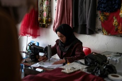 La couturière Rahima Alavi brode à la machine à coudre une écharpe dans sa boutique à Bamiyan, le 26 janvier 2026 en Afghanistan - © AFP - Wakil KOHSAR