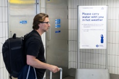 Un homme passe devant un panneau conseillant aux voyageurs d'emporter une bouteille d'eau avec eux, à la gare de Hammersmith, dans l'ouest de Londres, le 22 juin 2026 - © AFP - Brook Mitchell Un homme passe devant un panneau conseillant aux voyageurs d'emporter une bouteille d'eau avec eux, à la gare de Hammersmith, dans l'ouest de Londres, le 22 juin 2026 - © AFP - Brook Mitchell