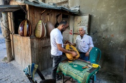 Le luthier palestinien Souhail Abou Chawich reçoit un ouds à réparer dans son atelier du camp de réfugiés de Nousseirat, dans le centre de la bande de Gaza, le 23 juin 2026 - © AFP - Eyad Baba