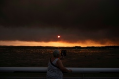 Une femme observe la fumée depuis la plage à Andernos-les-Bains lors d'un incendie dans la forêt de Lège-Cap-Ferret, dans le sud-ouest de la France, le 23 juillet 2026, alors qu'une partie de la zone voisine a été évacuée - © AFP - Olivier MORIN Une femme observe la fumée depuis la plage à Andernos-les-Bains lors d'un incendie dans la forêt de Lège-Cap-Ferret, dans le sud-ouest de la France, le 23 juillet 2026, alors qu'une partie de la zone voisine a été évacuée - © AFP - Olivier MORIN