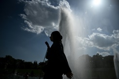 Une personne tient un éventail en passant devant une fontaine, le 22 juin 2026 à Paris - © AFP - JULIEN DE ROSA Une personne tient un éventail en passant devant une fontaine, le 22 juin 2026 à Paris - © AFP - JULIEN DE ROSA