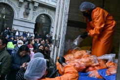 Un employé vend des poulets à des personnes faisant la queue au milieu des pénuries alimentaires provoquées par les barrages routiers, à La Paz, le 3 juin 2026 - © AFP - Marvin RECINOS