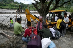 Des habitants regroupés près de la rivière Trishuli tandis que des ouvriers installent une tyrolienne au dessus du cours d'eau à Bidur au Népal le 2 septembre 2026 - © AFP - Arun SANKAR Des habitants regroupés près de la rivière Trishuli tandis que des ouvriers installent une tyrolienne au dessus du cours d'eau à Bidur au Népal le 2 septembre 2026 - © AFP - Arun SANKAR