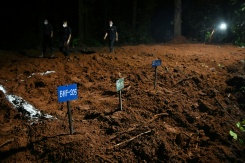 Des agents de police marchent à proximité de tombes de victimes non identifiées de la crue dévastatrice, le 30 août 2026 à Devghat au Népal - © AFP - Prakash MATHEMA Des agents de police marchent à proximité de tombes de victimes non identifiées de la crue dévastatrice, le 30 août 2026 à Devghat au Népal - © AFP - Prakash MATHEMA