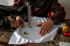 La couturière Rahima Alavi brode à la machine à coudre un tissu dans sa boutique à Bamiyan, le 26 janvier 2026 en Afghanistan - © AFP - Wakil KOHSAR