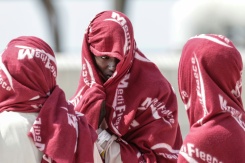 Des migrants attendent après avoir débarqué d'un navire après leur sauvetage en mer alors que leur embarcation avait pris feu lors d'une tentative de traversée de la Manche, au port de commerce de Boulogne-sur-Mer, le 4 août 2026 - © AFP - Sameer AL-DOUMY