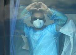 Un passager du navire de croisière MV Hondius, touché par un foyer d'hantavirus, fait un signe depuis un bus militaire après avoir débarqué dans le port de Granadilla de Abona, sur l'île de Ténérife, dans les îles Canaries (Espagne), le 11 mai 2026 - © AFP/Archives - JORGE GUERRERO