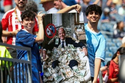 Des supporters présentent une affiche représentant le président de la Fifa, Gianni Infantino, dans une baignoire de billets, lors du quart de finale du Mondial-2026 entre la France et le Maroc à Foxborough, le 9 juillet 2026 - © AFP/Archives - FRANCK FIFE