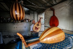 Le luthier palestinien Souhail Abou Chawich dans son atelier de réparation d'ouds, au camp de réfugiés de Nousseirat, dans le centre de la bande de Gaza, le 23 juin 2026 - © AFP - Eyad Baba