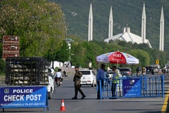 Des membres des forces de sécurité montent la garde le long d'une route temporairement fermée en prévision des pourparlers de paix américano-iranien, le 20 avril 2026 à Islamabad, au Pakistan  - © AFP - Aamir QURESHI